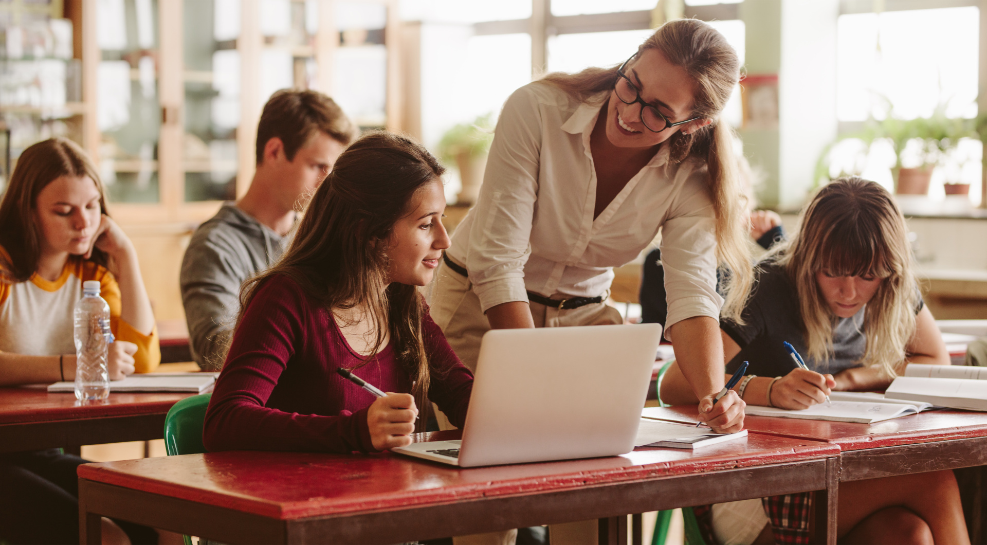 Lehrerin hilft Schülern im Klassenraum